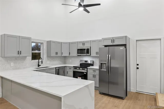 a kitchen with stainless steel appliances a refrigerator sink and stove