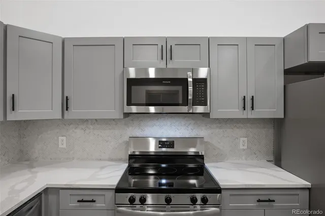 a kitchen with stainless steel appliances a stove and a microwave