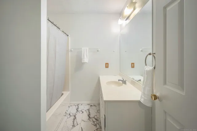 a bathroom with a sink a mirror and shower