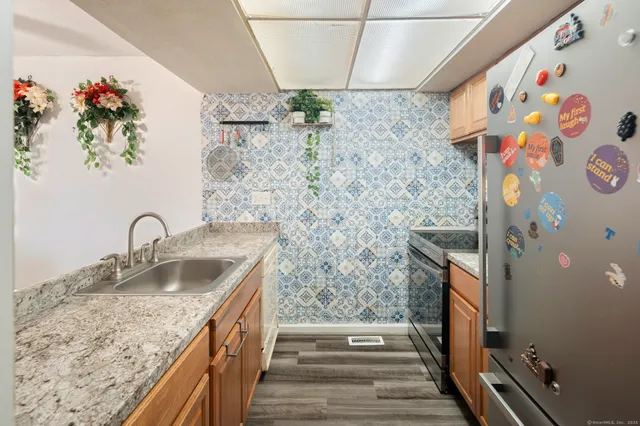 a bathroom with a granite countertop sink a mirror and shower