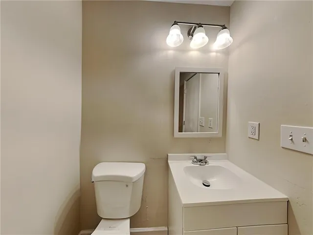 a bathroom with a toilet sink and mirror