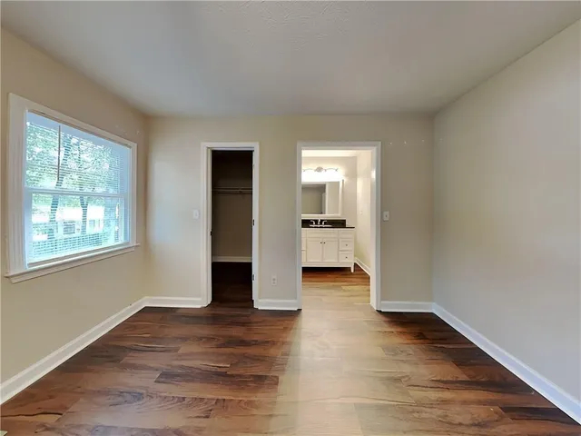 a view of empty room with wooden floor and window