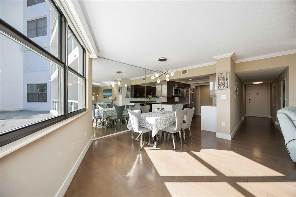 1050 Longboat Club Road, Unit 204 Longboat Key, FL 34228 - Photo 17 of 64 a dining room with furniture a rug a potted plant and a painting