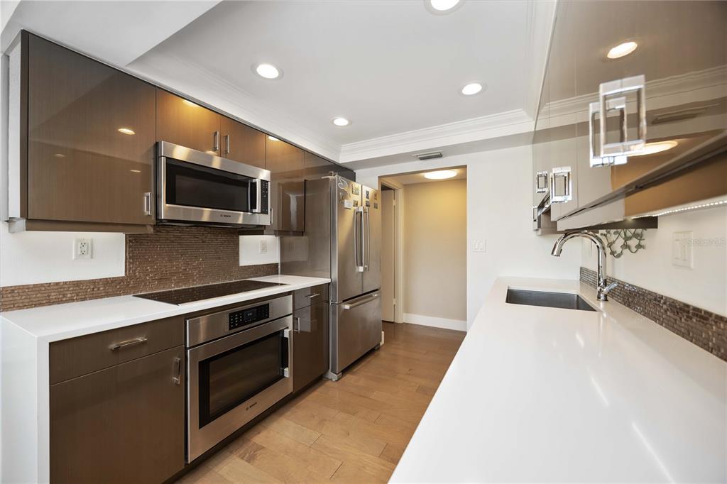 1050 Longboat Club Road, Unit 204 Longboat Key, FL 34228 - Photo 20 of 64 a kitchen with stainless steel appliances a sink a stove top oven a refrigerator and a microwave
