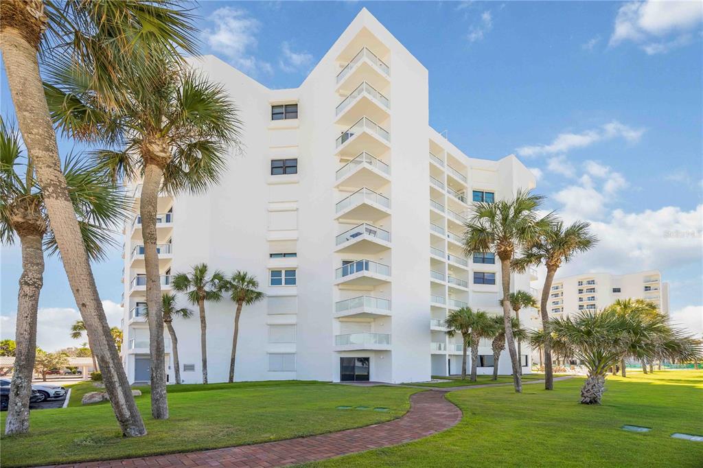 1050 Longboat Club Road, Unit 204 Longboat Key, FL 34228 - Photo 48 of 64 a front view of multi story residential apartment building with yard and green space