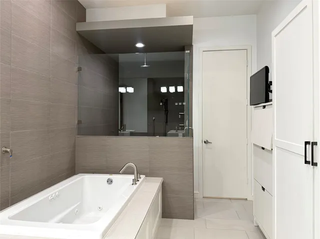 a bathroom with a tub sink and mirror