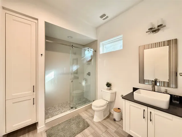 a bathroom with a granite countertop sink toilet and shower