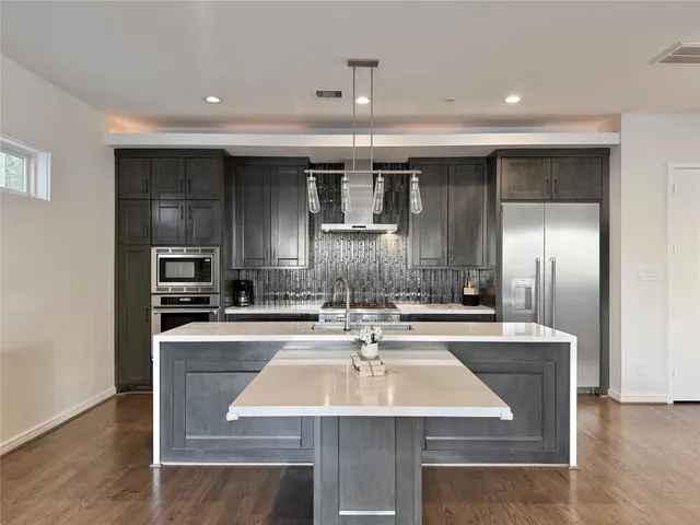 a kitchen with kitchen island a sink stove and refrigerator