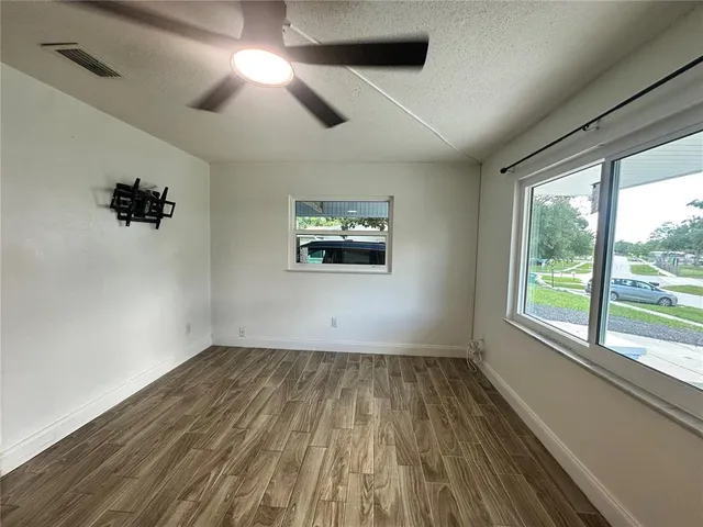 wooden floor in an empty room with a window