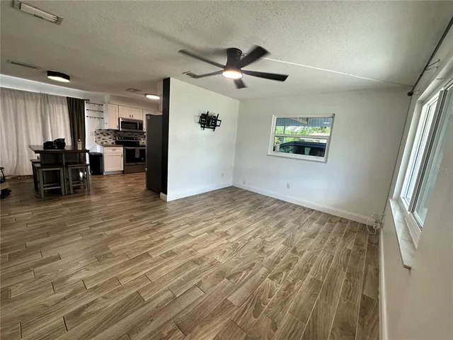 a view of empty room with wooden floor