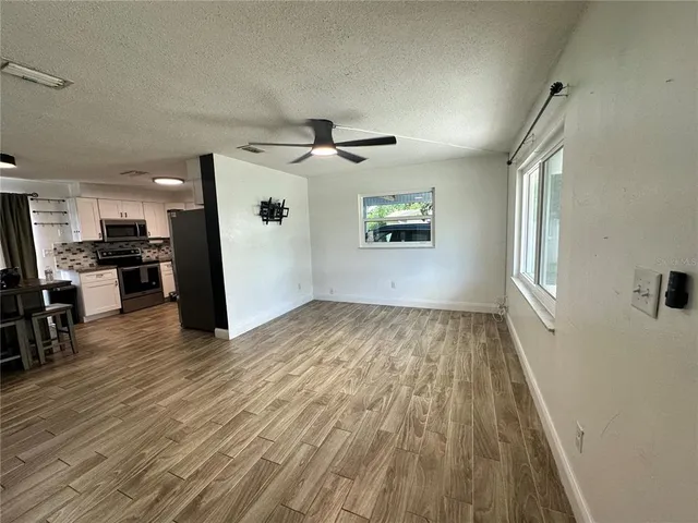 an empty room with wooden floor and windows