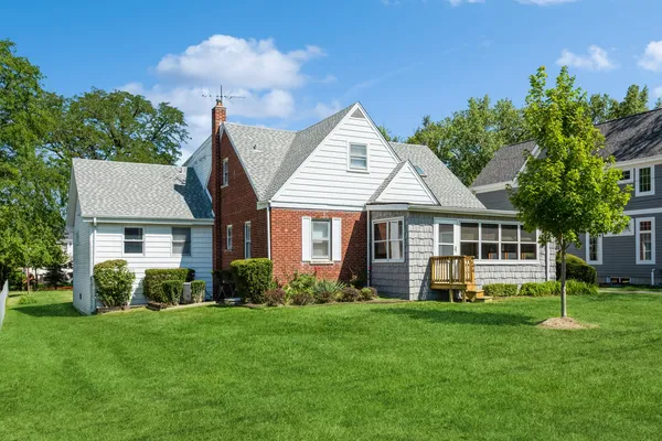 a front view of a house with a yard and potted plants