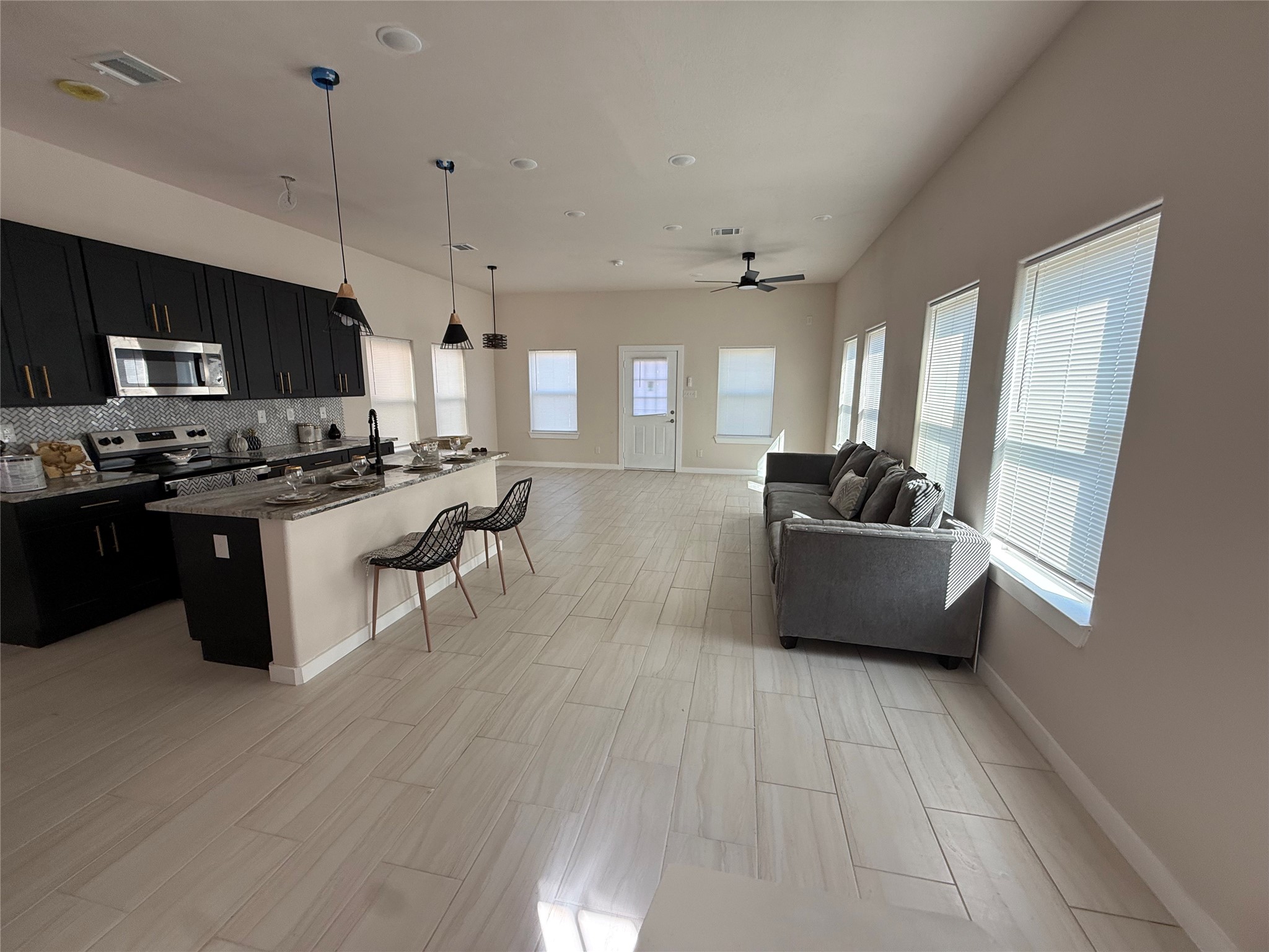 219 South 7th Street Beasley, TX 77417 - Photo 21 of 23 a kitchen with stainless steel appliances a sink a stove a refrigerator cabinets and living room view