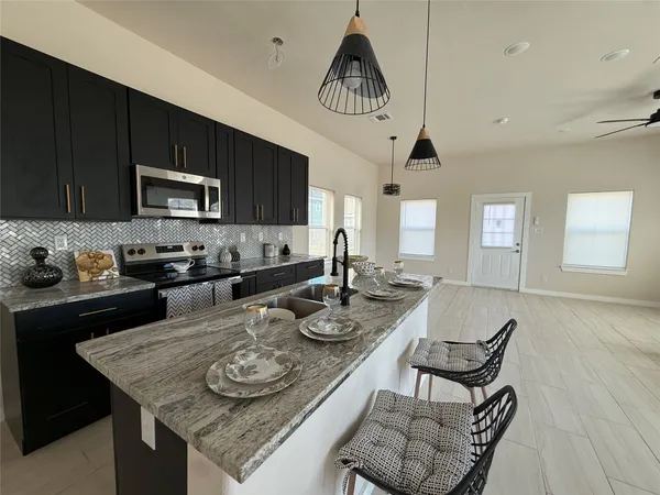 a kitchen with sink a stove and cabinets