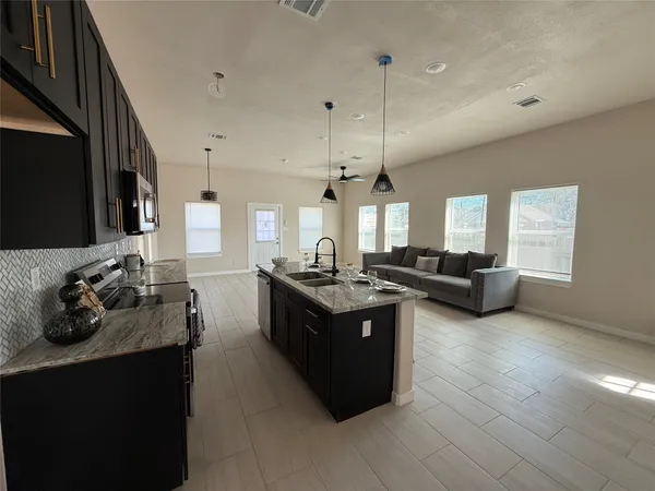 an empty room with windows and ceiling fan