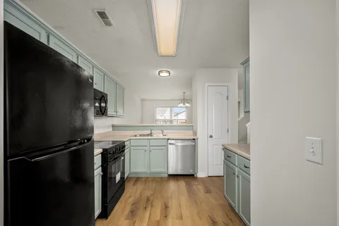 a kitchen with stainless steel appliances granite countertop a refrigerator a stove and a sink