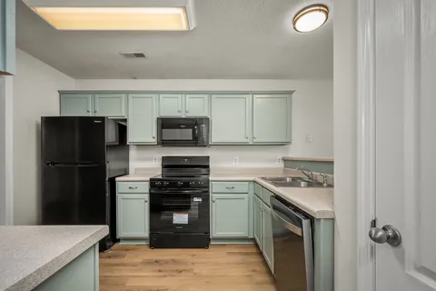 a kitchen with stainless steel appliances granite countertop a stove a refrigerator and a sink
