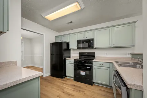a kitchen with stainless steel appliances a stove refrigerator sink and microwave