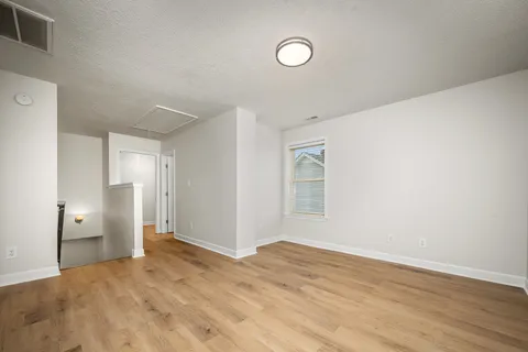 a view of empty room with wooden floor