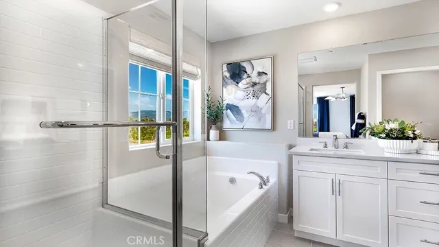 a spacious bathroom with a tub sink and mirror