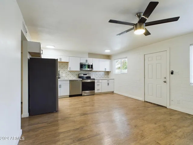 a view of kitchen with stainless steel appliances granite countertop a refrigerator and a stove top oven