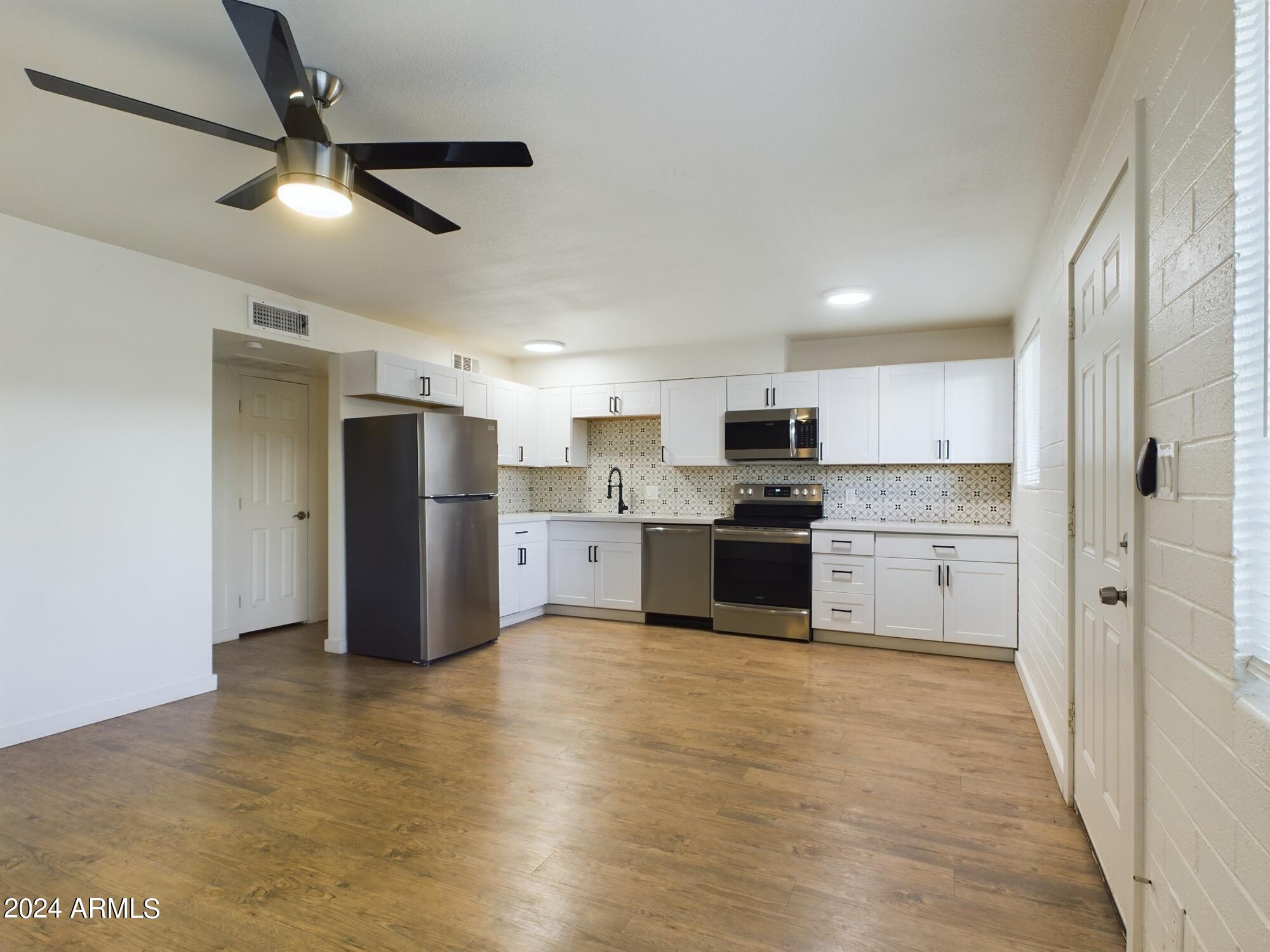 3027 North 37th Street, Unit 3 Phoenix, AZ 85018 - Photo 6 of 12 a kitchen with stainless steel appliances a refrigerator sink and cabinets