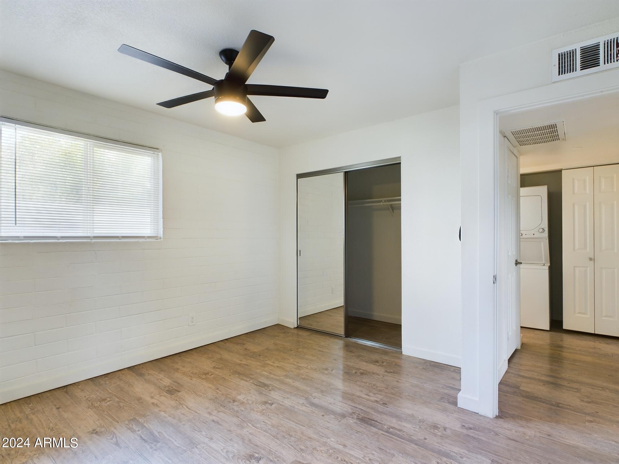 3027 North 37th Street, Unit 3 Phoenix, AZ 85018 - Photo 7 of 12 a view of an empty room with wooden floor and a window