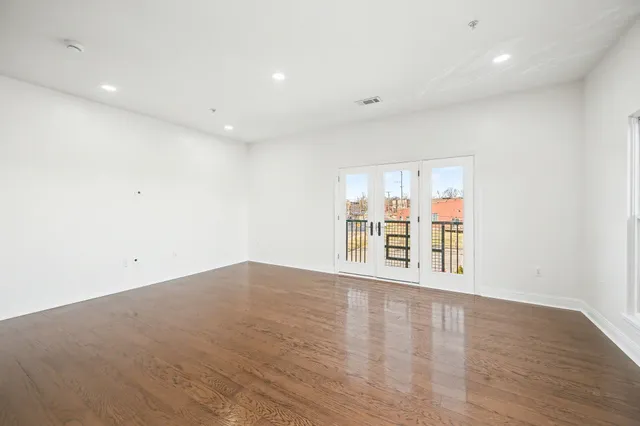 a kitchen with stainless steel appliances granite countertop a refrigerator a sink dishwasher and wooden cabinets with wooden floor