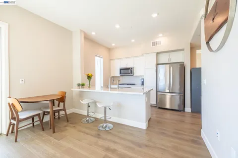 a kitchen with a sink appliances and wooden floor