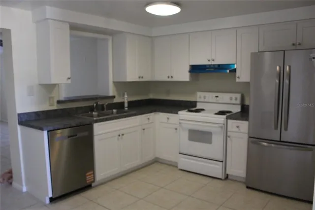 a kitchen with white cabinets and white appliances