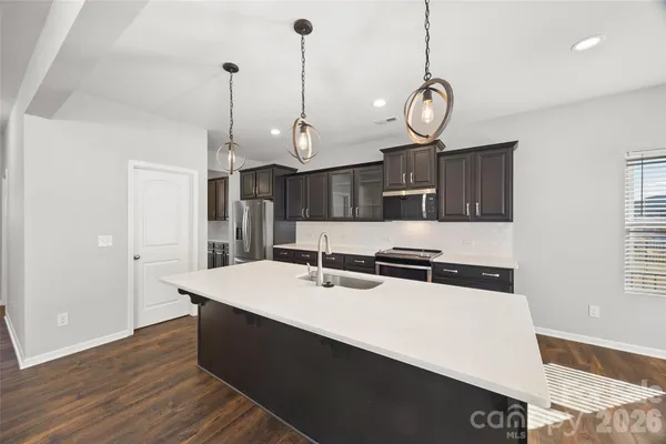 a very nice looking room with kitchen island a stove a sink a center island and furniture