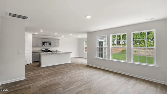 a view of kitchen with granite countertop refrigerator stove top oven and sink