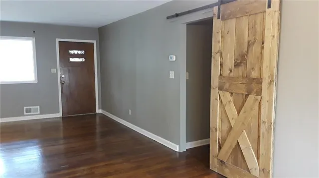 an empty room with wooden floor and closet