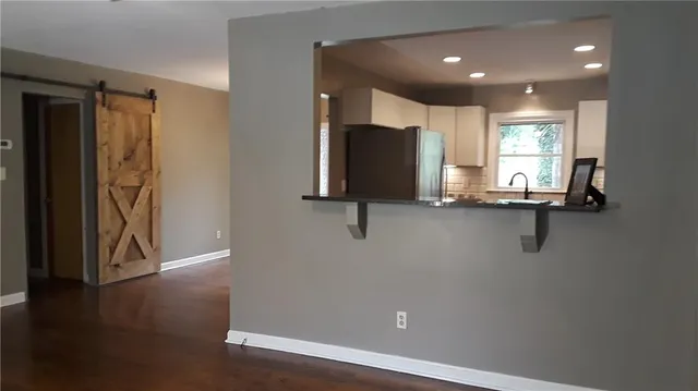 a view of a hallway with wooden floor and windows