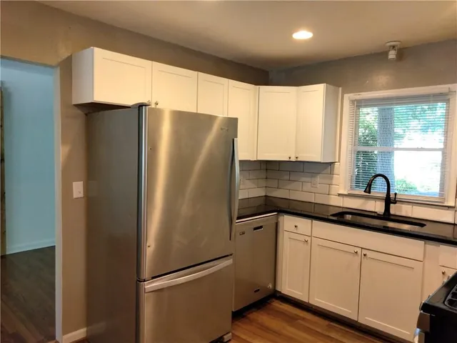 a kitchen with stainless steel appliances a refrigerator sink and cabinets