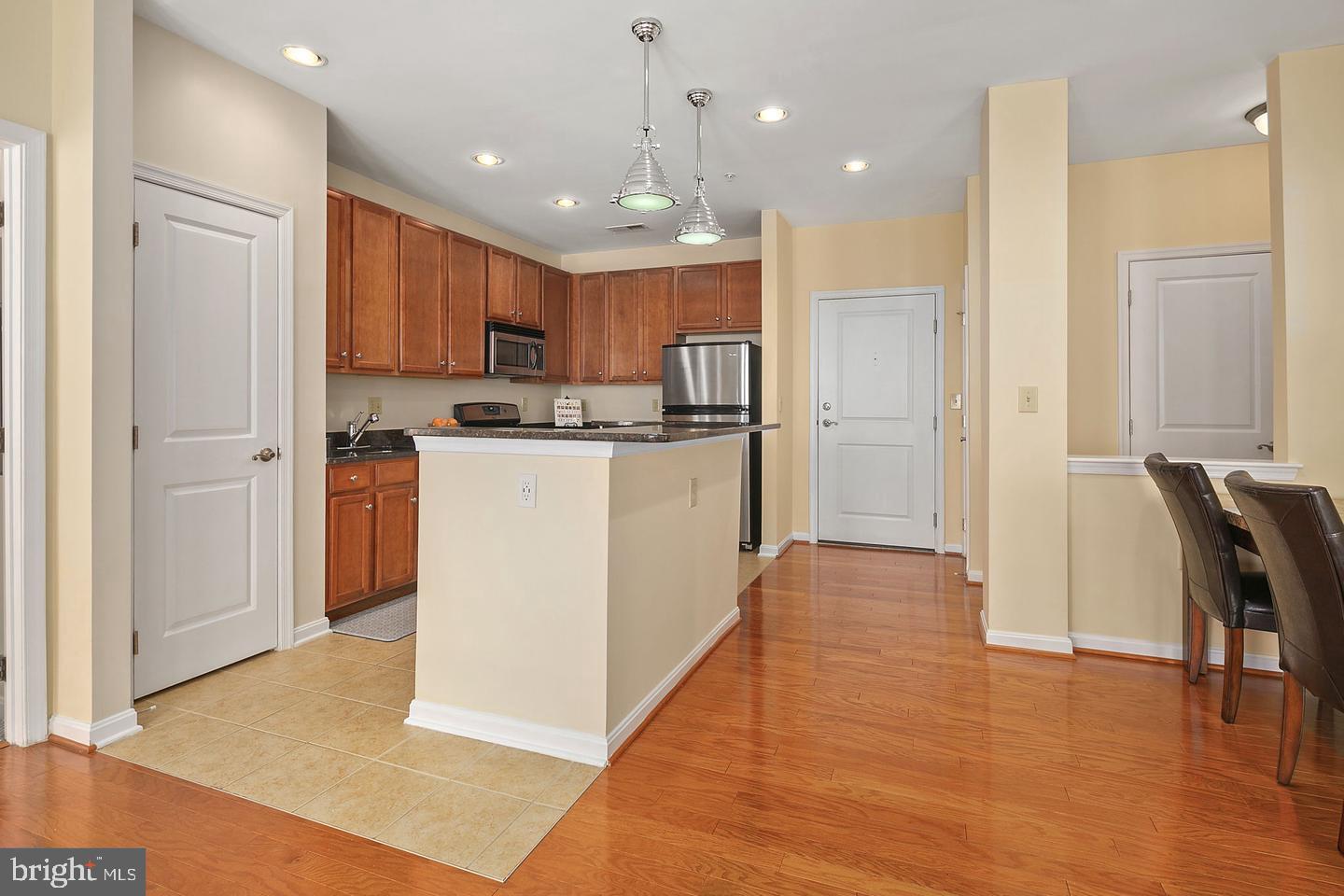2655 Prosperity Avenue, Unit 108 Fairfax, VA 22031 - Photo 15 of 47 a kitchen with stainless steel appliances granite countertop a refrigerator a stove top oven a sink dishwasher and a refrigerator with wooden floor