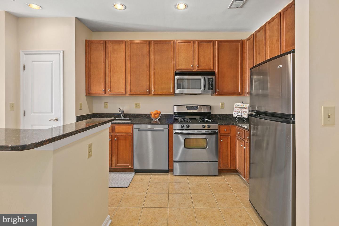 2655 Prosperity Avenue, Unit 108 Fairfax, VA 22031 - Photo 17 of 47 a kitchen with granite countertop a refrigerator stove and microwave