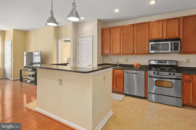 a kitchen with stainless steel appliances granite countertop a stove a sink and a refrigerator