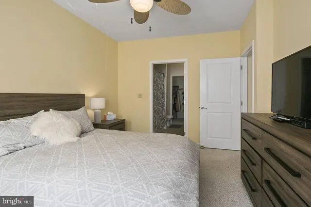 a bedroom with a bed and a flat tv screen on a dresser