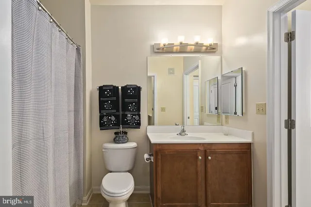 a bathroom with a toilet a sink and mirror