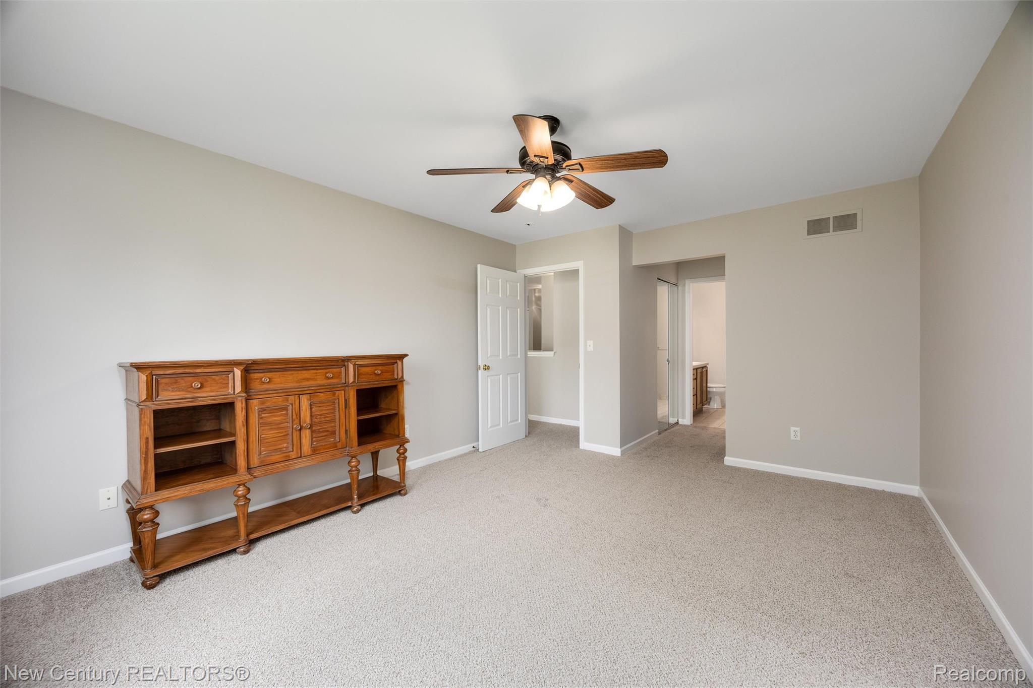 26013 Ranger Avenue Warren, MI 48091 - Photo 10 of 25 Unfurnished bedroom featuring ensuite bathroom, light carpet, and a ceiling fan