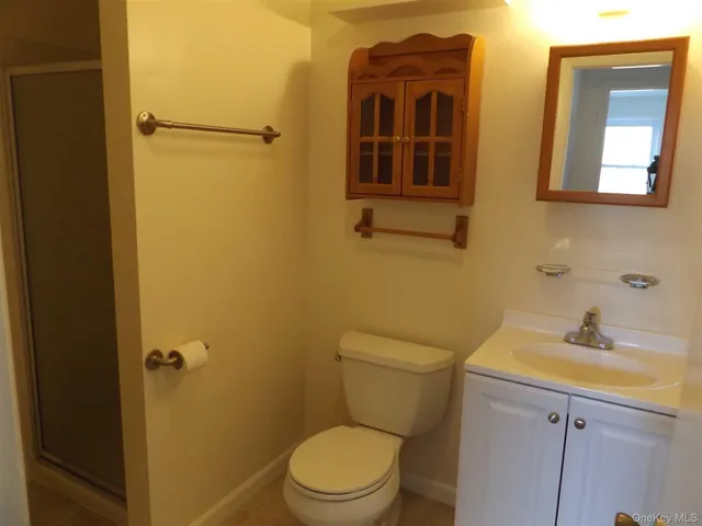 a bathroom with a toilet sink vanity and mirror