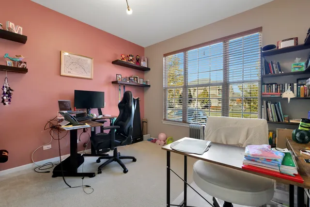 a view of a workspace with furniture and a window