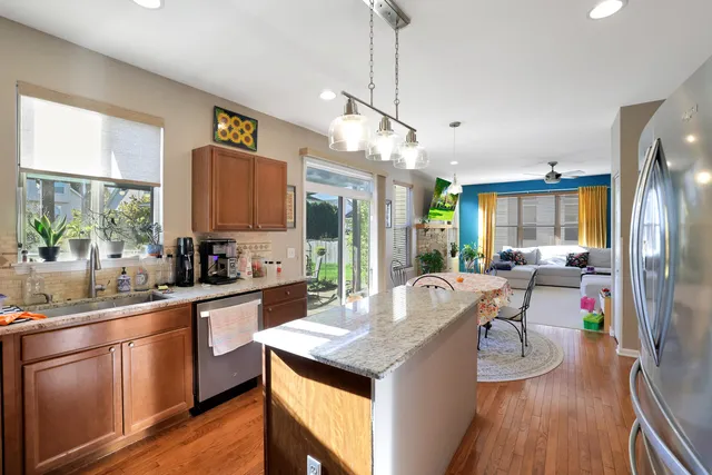a kitchen with stainless steel appliances granite countertop a sink refrigerator and cabinets