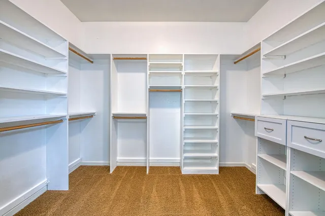 a view of walk in closet with empty racks