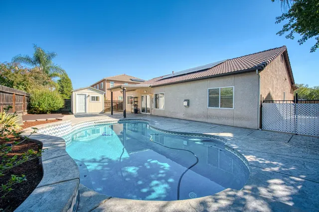 a view of a house with backyard and sitting area