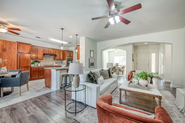 a living room with furniture kitchen view and a large window