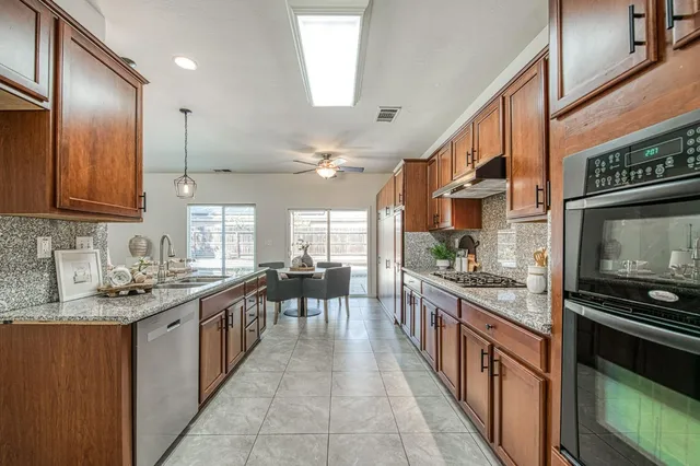 a large kitchen with lots of counter space and stainless steel appliances