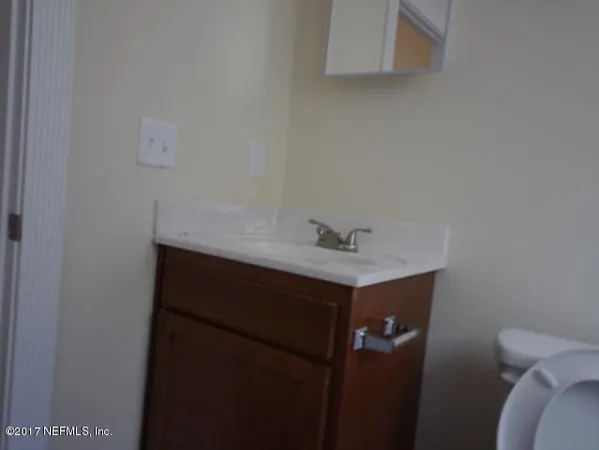 a bathroom with a sink vanity and toilet
