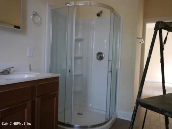 a bathroom with a shower sink and mirror